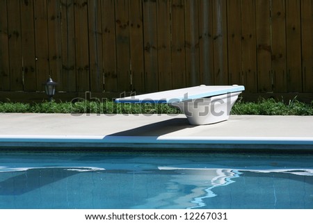 Swimming pool with concretes deck and diving board
