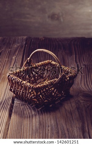 wooden empty basket over an aged table and wood background