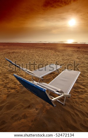 sunset or sunrise on a beach with comfortable little bed