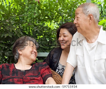 happy senior couple and their daughter