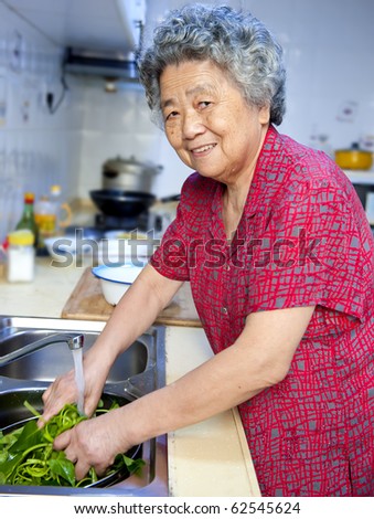 happy grandmother  cooking healthy foods in kitchen