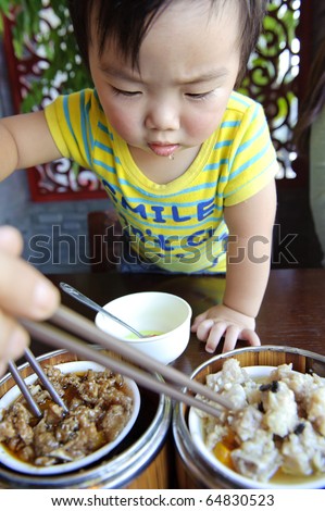 a cute baby is eating (The text on the clothes of baby : SMILE,Don\'t Cry)