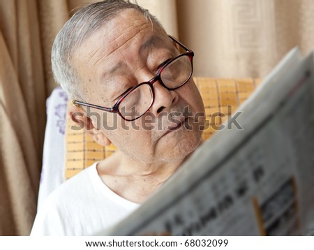 a senior man is reading newspaper