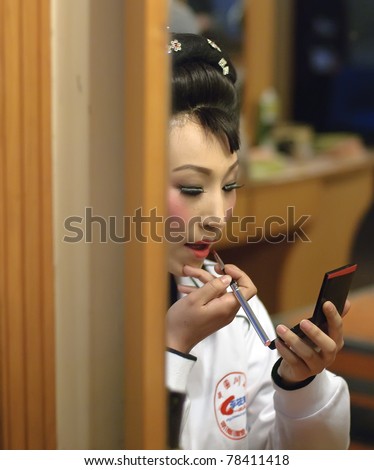 CHENGDU, CHINA- FEB. 27: An unidentified Chinese opera actress is painting her face backstage at JinJiang theater on Feb. 27, 2008 in Chengdu, China.