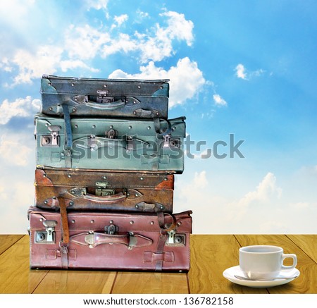 Ready for travel in morning concept, Old travel bag and coffee cup on wooden table
