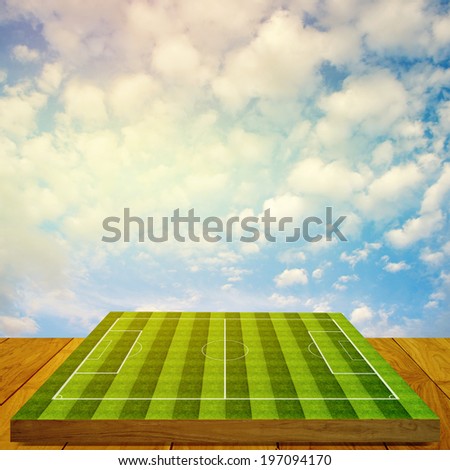 Soccer field board game on wooden floor with nice sky background, Summer sport concept