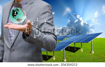 Sustainable energy concept, Solar farm with businessman carry virtual world