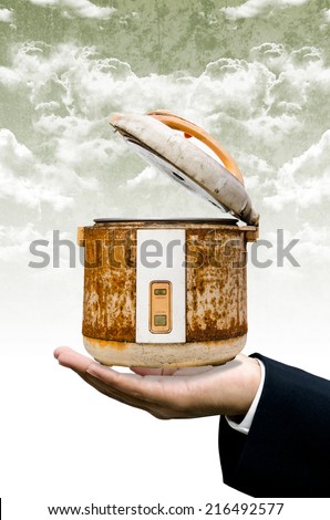 Time to change your rice cooker concept, Old rice Cooker in businessman hand