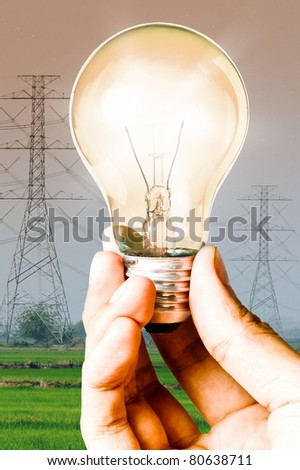 Light bulb in the hand with electricity post background, Save energy and power concept