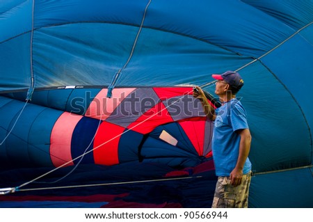 CHIANG MAI - NOV 26: Unidentified man fill hot air in balloon during Thailand balloon festival 2011 at Prince Royal college in Chiang mai, Thailand on Nov 26, 2011.