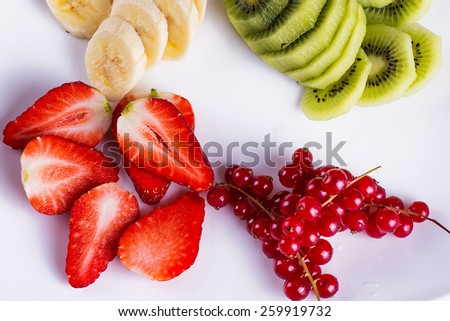 Strawberries, banana slices, berries with kiwi on a plate