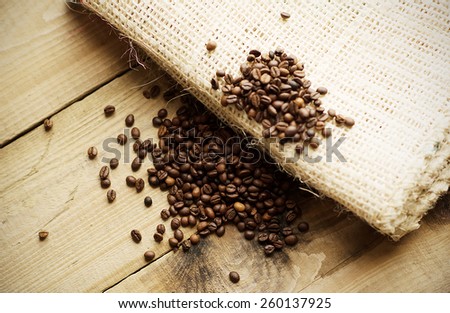 Coffee beans on wooden background and on coffee bag