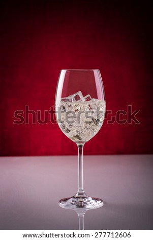 Glass of sparkling wine over ice cubes; preparing wine-based long drink