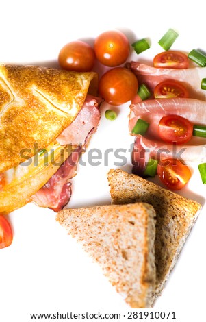 Omelette with ham and vegetables on white plate