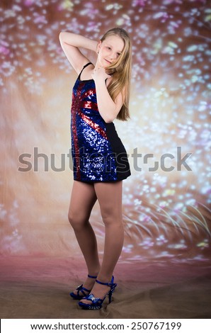Beautiful teen girl in party UK sparkle dress with high heels posing in studio