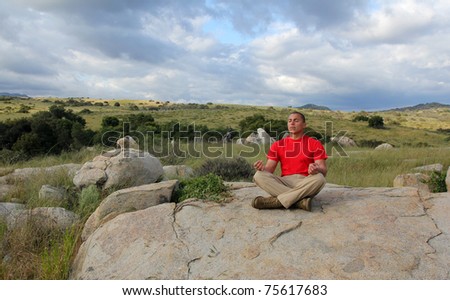 Fit young man meditates in nature