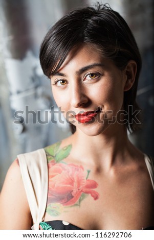 Color head shot of a young girl with red lipstick looking into camera with a corrugated background