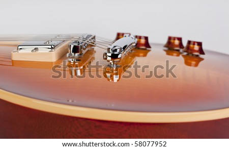 Close up of pickup, bridge and knobs on a sunburst electric guitar