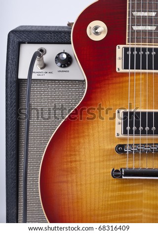 Electric sunburst guitar with old amplifier and patch cord