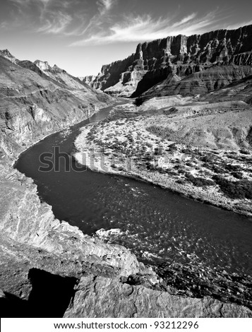 Black and White of the winding Colorado River through the Grand Canyon from up on top of a large mesa looking down at the river