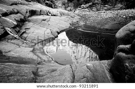 Black and White of a small puddle in a side canyon along the Colorado River in the Grand Canyon with a reflection of the mountain