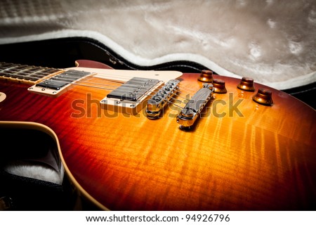 Side View of the Body of a Sunburst Electric Guitar Laying in a Hard Shell Electric Guitar Case