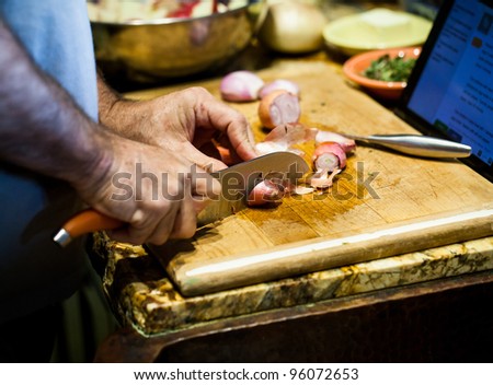 Cutting Onions on a Cutting Board atop a Granite Countertop in the Kitchen