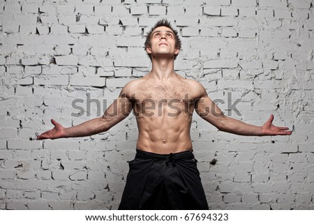 muscular man freedom fly at brick background