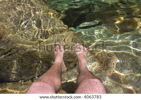 men legs inside crystal clear water
