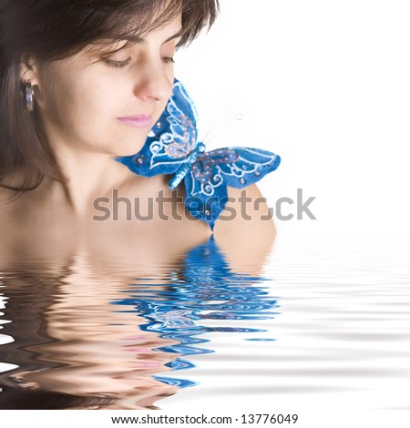beautiful young woman with blue butterfly in her naked shoulder - focus on the eye