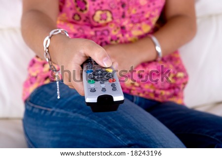 young woman holding a television remote control