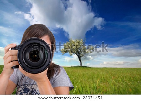 young female photographer with digital photo camera shotting landscape scene