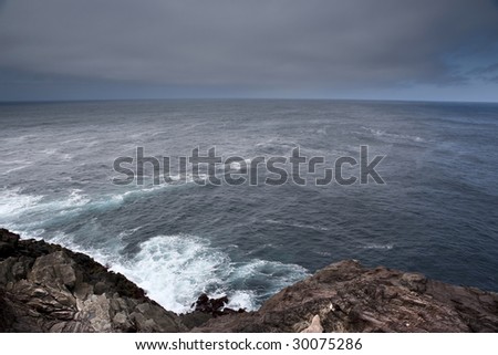 azores shore seascape with dark clouds and rocks - landscape orientation