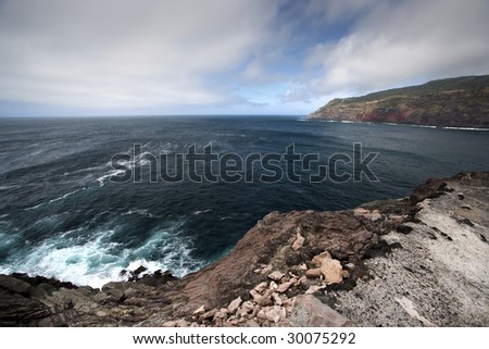 azores, terceira island shore seascape with dark clouds and rocks - landscape orientation
