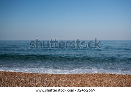 empty beach seascape with calm water and perfect blue sky - landscape orientation