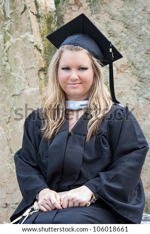Portrait of a female college graduate student. She is wearing a graduation cap and gown on graduation day.