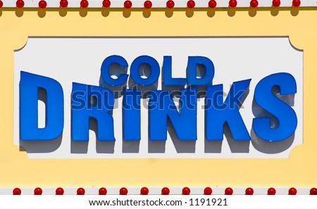 Large sign advertising cold drinks for a restaurant on a beach boardwalk