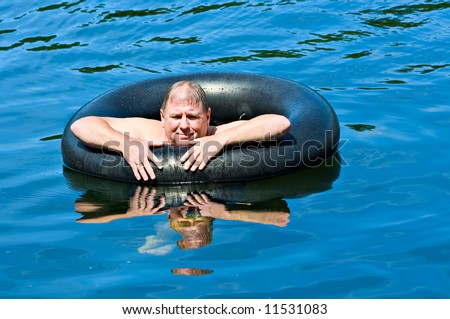 A man in water floating on an inner tube