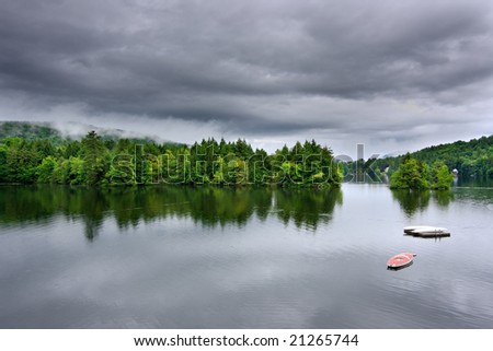 A lake during a rain storm. There are dark, ominous rain clouds overhead