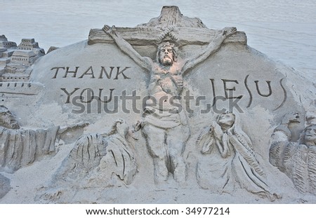 A sand sculpture on a beach of the crucifixion of Jesus