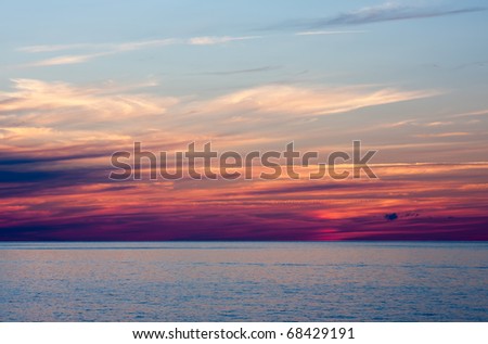 An Evening Sunset Over Water. The sky is blue at the top and purple closer to the water