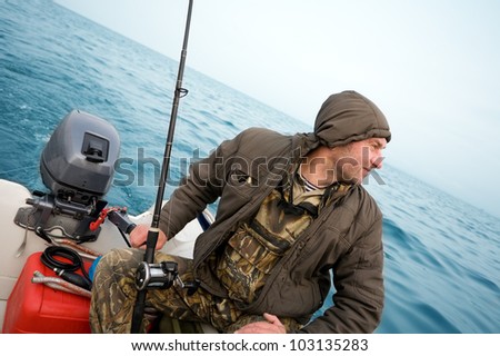 Fisherman fishing a salmon trolling in the sea.
