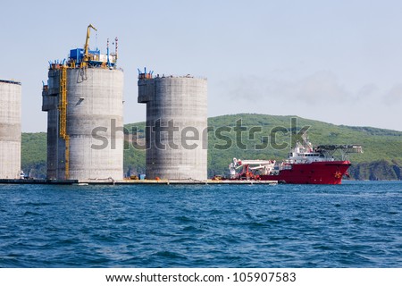 Ocean tug at the base of offshore oil drilling platform. Sea Japan. Russian coast.
