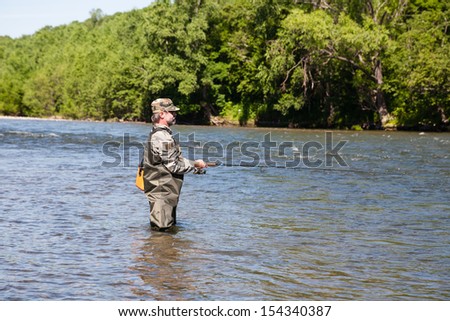 Fisherman catches of salmon in a mountain river.