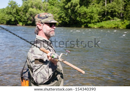 Fisherman catches of salmon in a mountain river.