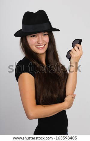Beautiful smiling Asian young woman in a felt hat. Mixed race Asian Caucasian girl.