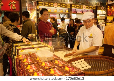 MACAU, CHINA - OCTOBER 31: Confectioner manufactures biscuits in candy store. Manufacture and sale of confectionery products is very popular business in Macau.