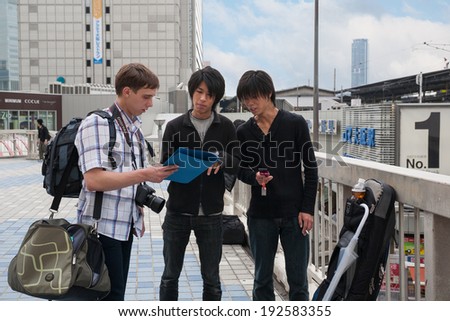 OSAKA, JAPAN - MAY 28, 2008: Tourist clarifies details of the route from the locals. Osaka - the third largest city in Japan, every year hundreds of thousands tourists and businessmen attend city.