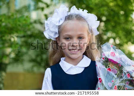 First grader girl with flowers in their first day of school. Russia.