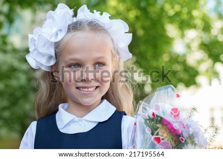 First grader girl with bows in the first day of school.
